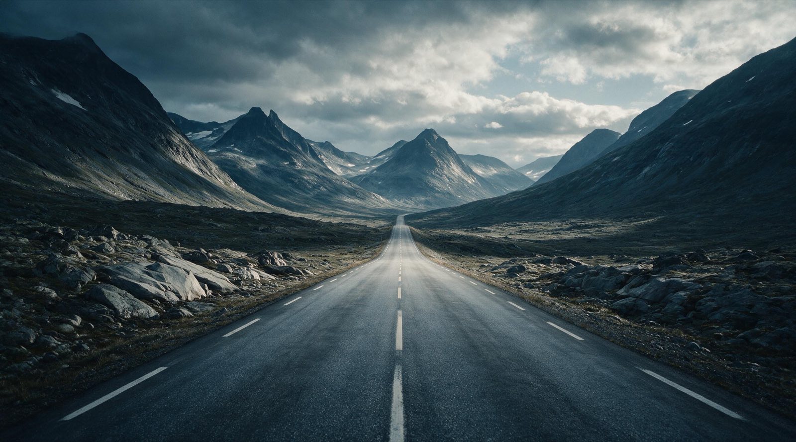 An empty mountain road disappearing north